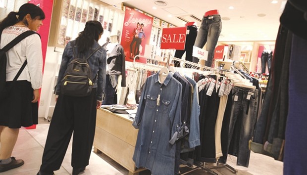 Women look at clothes on sale at a retail store in Tokyo. Japanu2019s consumer prices fell in September for the seventh straight month, data showed yesterday, heaping more pressure on the central bank to push back its inflation target deadline.