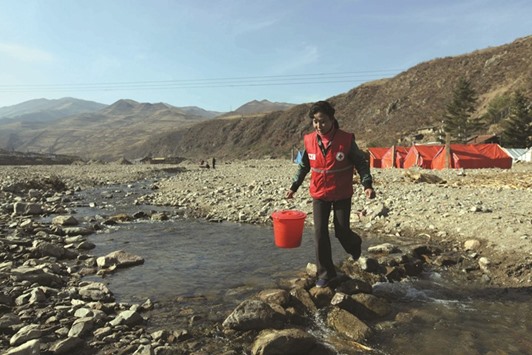 This recent undated handout photo received by the Finnish Red Cross yesterday shows Pak Un-hye, 37, a North Korean Red Cross volunteer, who was made homeless when her home in Kangson-gu, Musan County, was swept away by the August 30 floods, helping out in Musan County in North Koreau2019s North Hamgyong Province. Pak now lives in a temporary shelter with her 11-year-old daughter where she checks on the welfare of other displaced people in her community.