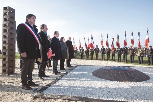 Hollande and dignitaries stand in line with war veterans during a ceremony to pay tribute to the memory of Roma and travelling people interned by World War II Vichy regime and in the early months of the post-war government.