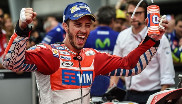 Ducati Teamu2019s Italian rider Andrea Dovizioso celebrates at the parc ferme after taking pole position after the qualifying session for the Malaysian MotoGP at the Sepang International circuit yesterday.