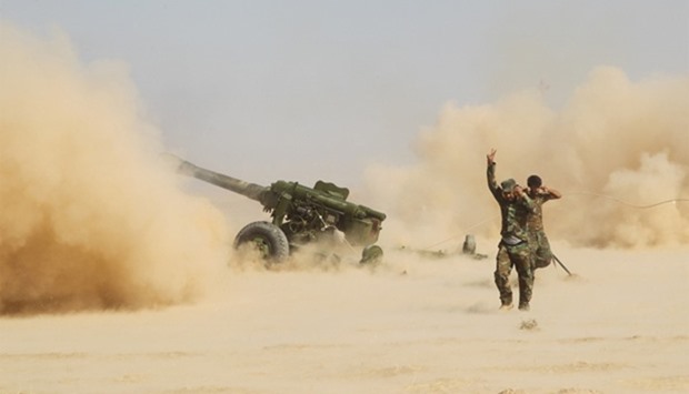 PMF personnel fire artillery during clashes with Islamic State militants south of Mosul