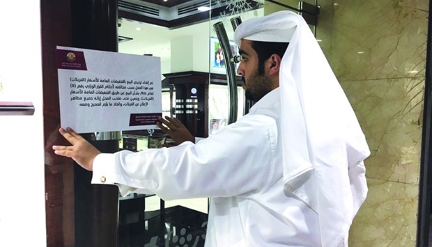 An official from the MEC pasting a violation notice on the door of a jewellery outlet