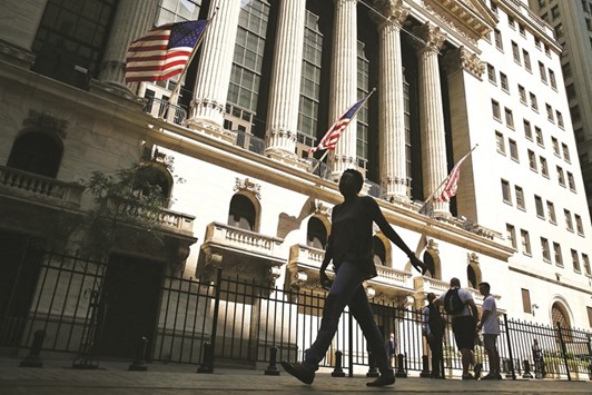 People walk by the New York Stock Exchange. The S&P 500 Index capped its third weekly loss in the past four, pushing investors towards the biggest monthly loss since January.