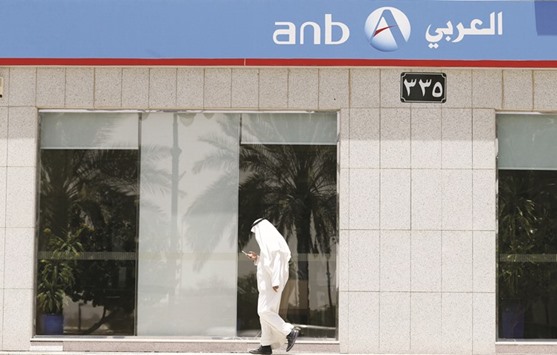 A Saudi man walks past ANB Bank in Riyadh. The lending cost drop comes after the kingdom sold the developing worldu2019s biggest sovereign bond offering, reduced its weekly debt issuance and pledged to inject billions of riyals into the banking sector to boost liquidity.