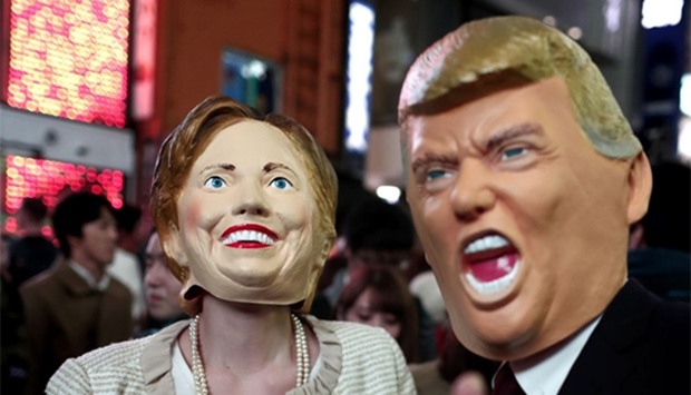 people wearing costumes of US presidential candidates Hillary Clinton (L) and Donald Trump (R)