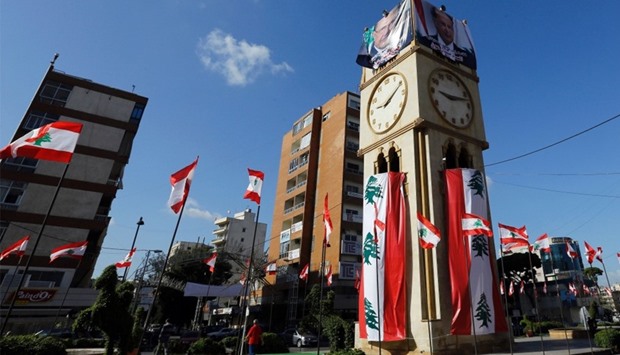 clock tower covered in Lebanese flags ahead of a parliament session expected to elect former general Michel Aoun as president
