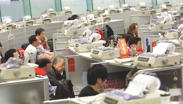 Traders monitor transactions at the Hong Kong Stock Exchange. The Hang Seng closed down 0.1% to 22,934.54 points yesterday.