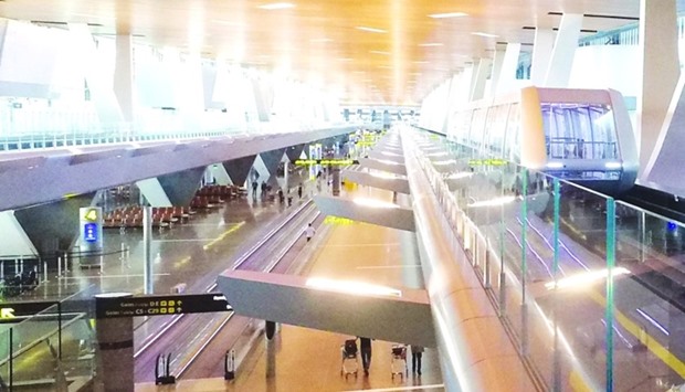 One of the passenger trains, right, traverses the stretch of the Hamad International Airport passenger terminal.