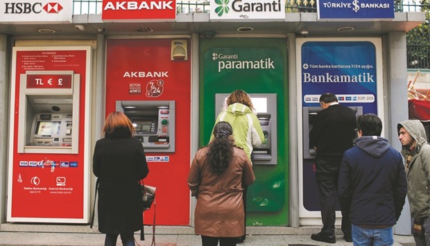 Customers queue outside ATMs operated by HSBC, Akbank, Garanti Bank and Turkiye Garanti in Istanbul (file). Akbank, Turkeyu2019s second-largest lender by market value, followed rival Isbank in cutting mortgage rates for a second time in three months after the nationu2019s president called on lenders to ease borrowing costs.