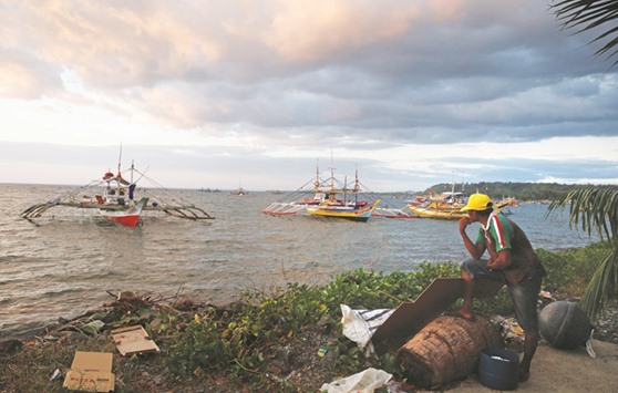 A fisherman looks at the fishing boats that just returned from the disputed Scarborough Shoal, as they are docked at the coastal village of Cato in Infanta, Pangasinan yesterday.