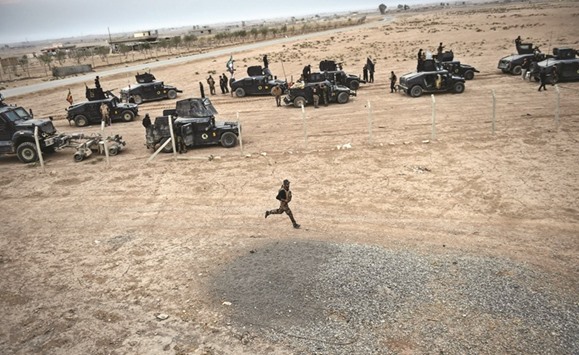 Members of the Iraqi Counter Terrorism Service (CTS) drive near the village of Bazwaya, on the eastern edges of Mosul, tightening the noose on Mosul as the offensive to retake the Islamic State group stronghold entered its third week yesterday.