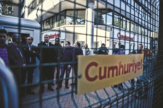 Journalists wait in front of the Cumhuriyet newspaperu2019s headquarters in Istanbul yesterday during a police operation.