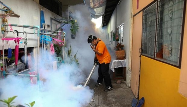 A city worker fumigates to control the spread of mosquitoes at a university in Bangkok.