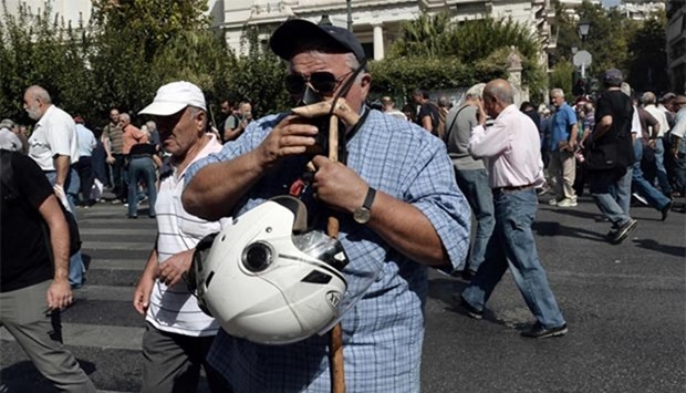 A pensioner reacts after being sprayed with pepper during a protest in Athens on Monday.