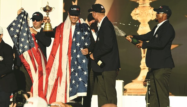 USA captain Davis Love III and vice-captain Tiger Woods celebrate during the trophy ceremony at Hazeltine National Golf Course in Chaska, Minnesota,  on Sunday.