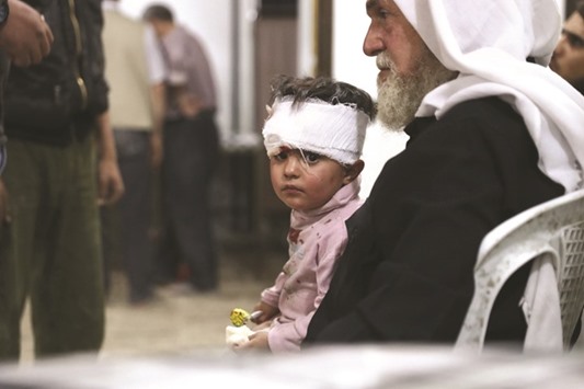 An injured child waits after receiving treatment at a makeshift hospital yesterday, following air strikes in the rebel-held town of Douma, on the eastern outskirts of the capital Damascus.