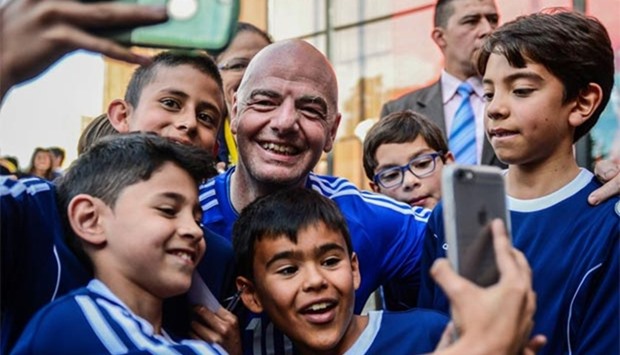 FIFA president Gianni Infantino takes selfies during a friendly football match with former Colombian players and international football stars in Bogota on Monday.