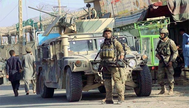 Afghan security forces keep watch in front of their armoured vehicle in Kunduz on Tuesday.