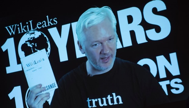 Julian Assange, founder of the online leaking platform WikiLeaks, is seen on a screen as he addresses journalists via a live video connection during a press conference on the platform's 10th anniversary on October 4, 2016 in Berlin