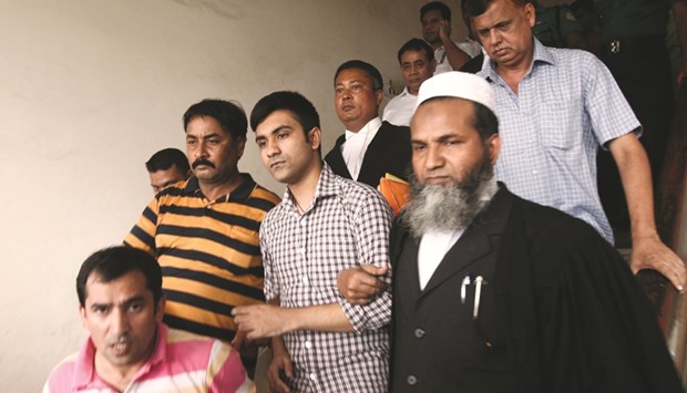 Canadian student Tahmid Hasib Khan, centre, walks with officials after a court appearance in Dhaka yesterday.