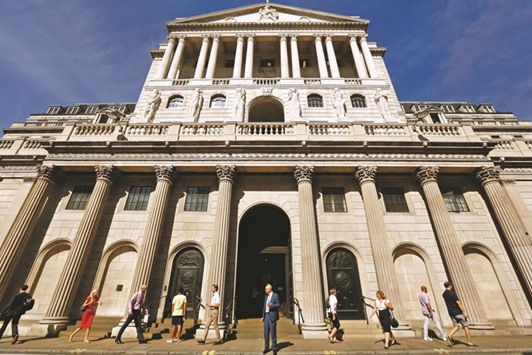 Pedestrians walk past the Bank of England building in the City of London. The BoE, which signalled a few weeks ago that a fresh interest rate cut was likely next month, has been put on the spot by signs that Britainu2019s economy has weathered the initial shock of the Brexit vote better than expected.