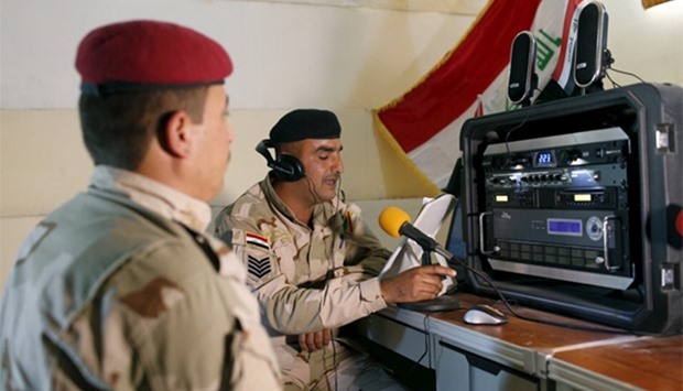 Iraqi soldiers work at a radio station at Makhmour base, Iraq