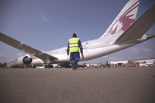 A labourer walks towards a Qatar Airways Boeing 787 Dreamliner at an airshow in Singapore (file). Qatar Airways is in the process of firming up an order for Boeing jets, people familiar with the situation said.