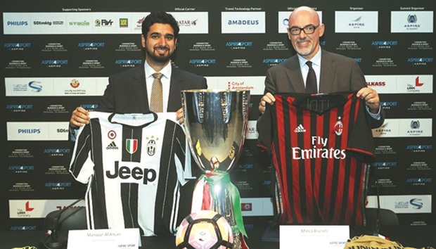 Mansoor al-Ansari, QFA General Secretary (L) and Marco Brunelli, Director General of Serie A, pose with the team jerseys during the announcement.