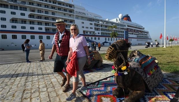 Tourists walk past camels after they disembarked from the MS Europa cruise liner at La Goulette on Thursday.