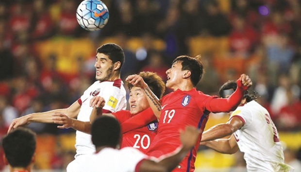 South Koreau2019s Jang Hyun-soo and Jung Woo-young vie for the ball with Qataru2019s Karim Boudiaf during the World Cup 2018 Qualifier in Suwon, South Korea, yesterday. (Reuters)