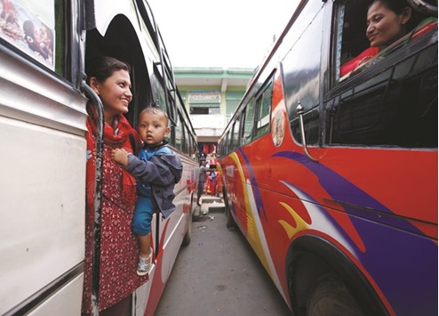 Passengers speak with each other as they wait for long distance buses to head towards their village for Dashain festival, at the bus station in Kathmandu yesterday.
