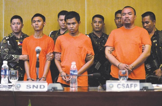 Suspected extremists responsible for the Davao bombing, are escorted by soldiers during a press conference at Camp Aguinaldo in Quezon city, Metro Manila, yesterday.