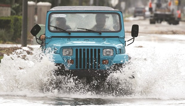 A Jeep drives down a flooded street, in Jacksonville Beach, Florida.