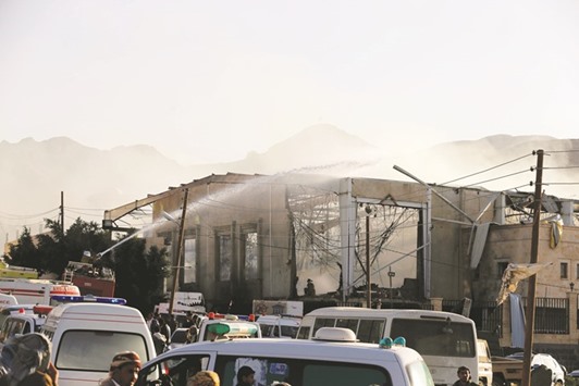 A fire engine sprays water on a damaged building at the site of an air strike on mourners at a hall where a wake for the father of Jalal al-Roweishan, the interior minister in the Houthi-dominated Yemeni government, was being held, in Sanaa yesterday.