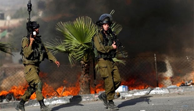 Israeli soldiers are seen during clashes with Palestinian protesters in the West Bank town of Al-Ram, near Jerusalem, on Sunday.