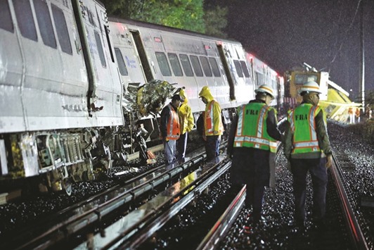 Emergency responders work near a train that derailed yesterday near New Hyde Park on Long Island in New York.
