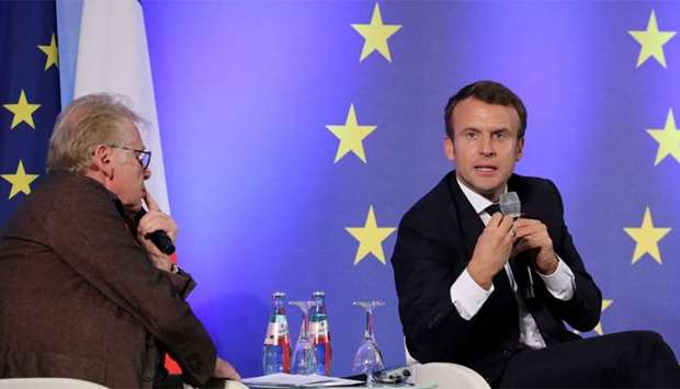 French President Emmanuel Macron (R) speaks next to European MP Daniel Cohn-Bendit (L)