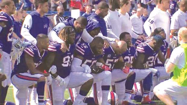 Buffalo Bills players kneel in protest during the national anthem prior to their NFL game against the Denver Broncos.