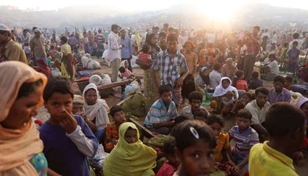 The sun rises as thousands of Rohingya refugees who fled from Myanmar a day before wait by the road where they spent the night between refugee camps, near Cox's Bazar.