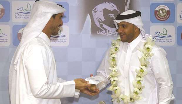 Salah al-Mannai (left) fetes Amro al-Hamad for his achievement.