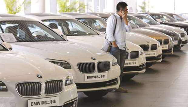 A man takes a look at second-hand BMW cars at a shop in Beijing. Automakers are considering the possibility of opening an assembly plant in the eastern Chinese city of Changshu, a BMW executive said.
