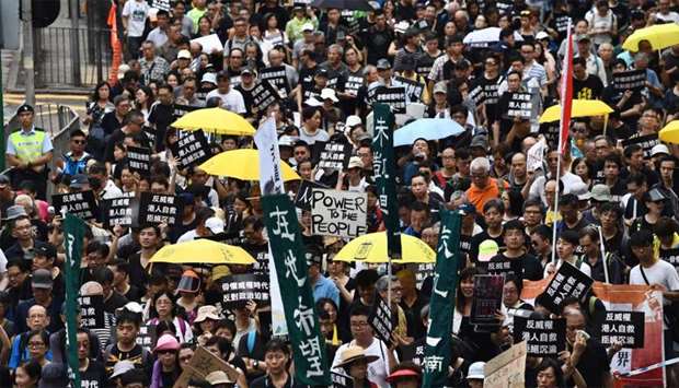 Activists hold banners and placards as they take part in an annual protest march on China's national day in Hong Kong