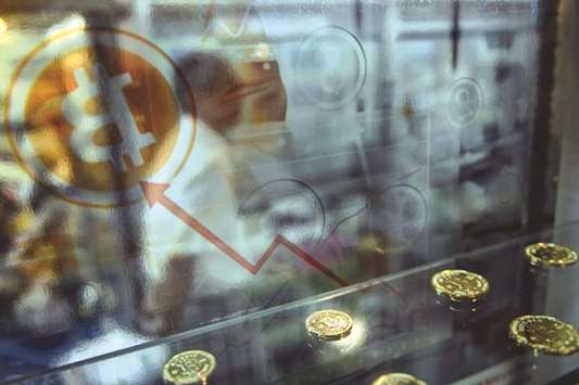 A man walking past a display cabinet containing models of bitcoins in Hong Kong. Beijingu2019s decision to shut down bitcoin trading platforms has left investors scrambling to cut their losses and threatens to deprive the crypto-currency of a crucial market.