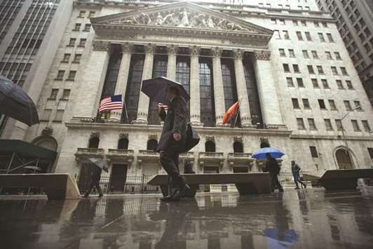 Pedestrians walk past the New York Stock Exchange. US investors are not rewarding companies for generating good earnings consistently, opting instead for a  stockpicking strategy that might be called u201cgrowth at a high cost.u201d