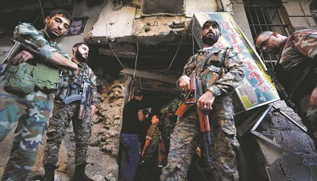 Syrian Army soldiers stand near the police headquarters in central Damascus, yesterday.