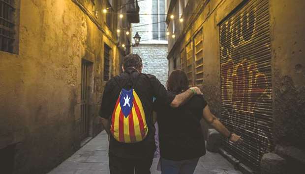 A man wears a backpack with the colours of the Catalan separatist flag as he walks in El Born district in Barcelona, Spain, yesterday.