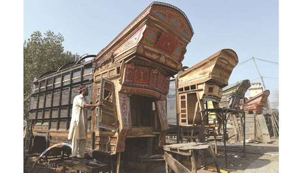 A Pakistani craftsman prepares a truck body before applying colourful decorations onto it at a workshop in Peshawar yesterday.