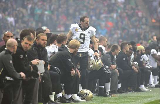 New Orleans Saints players kneel prior to the playing of the United States national anthem as quarterback Drew Brees (centre) looks on during the NFL International Series game against the Miami Dolphins in London. (USA TODAY Sports)
