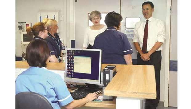 Prime Minister Theresa May and Health Secretary Jeremy Hunt speak to nurses and members of staff as they visit the renal transplant unit at the Royal Liverpool University Hospital, Liverpool, Britain, yesterday.