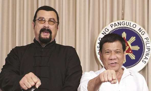 Philippine President Rodrigo Duterte does his signature fist bump with US actor Steven Seagal during a courtesy call at Malacanang Palace in Manila.